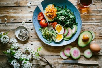 Healthy weight loss essentials: fresh salad, vegetables, with boiled egg and avocado arranged neatly on a light surface