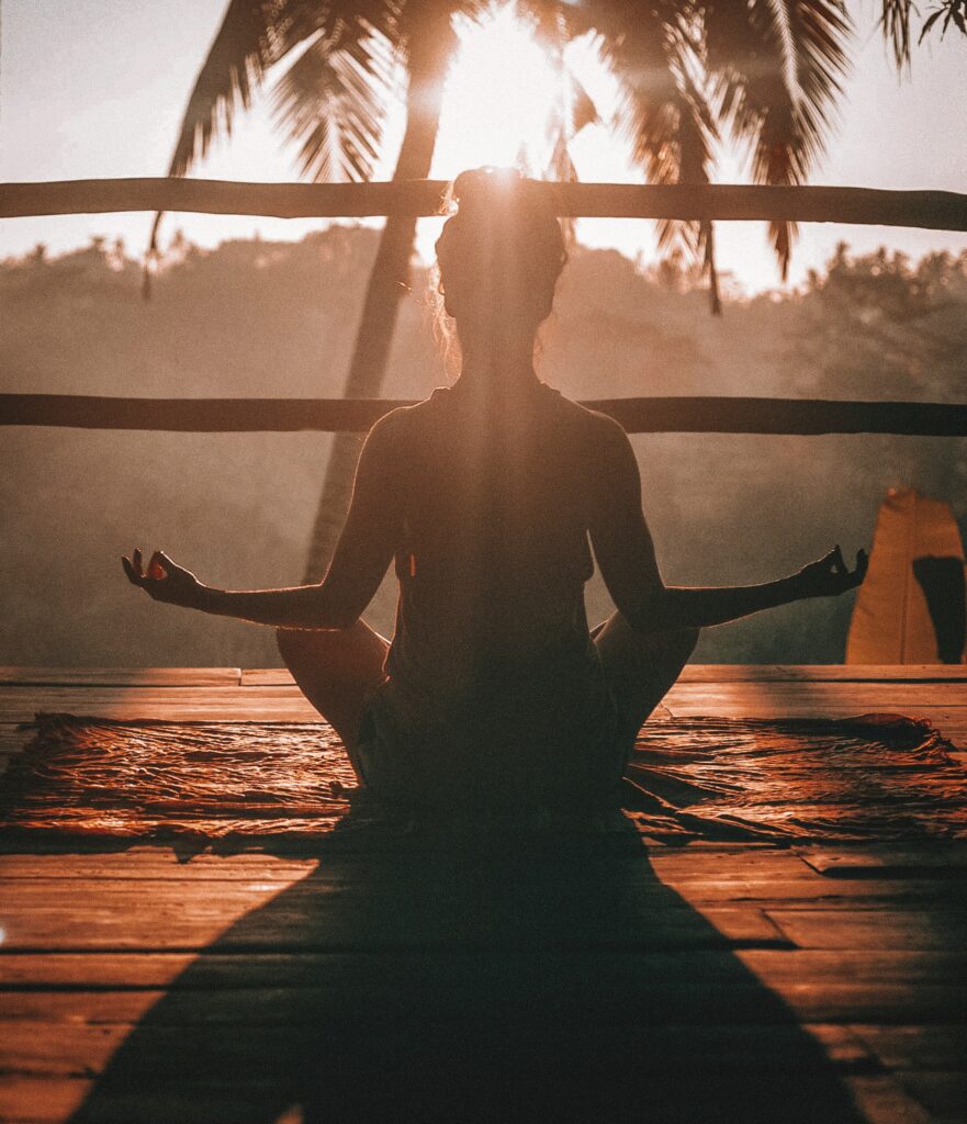 Woman seated in meditative yoga pose on wooden floor, peaceful and centered